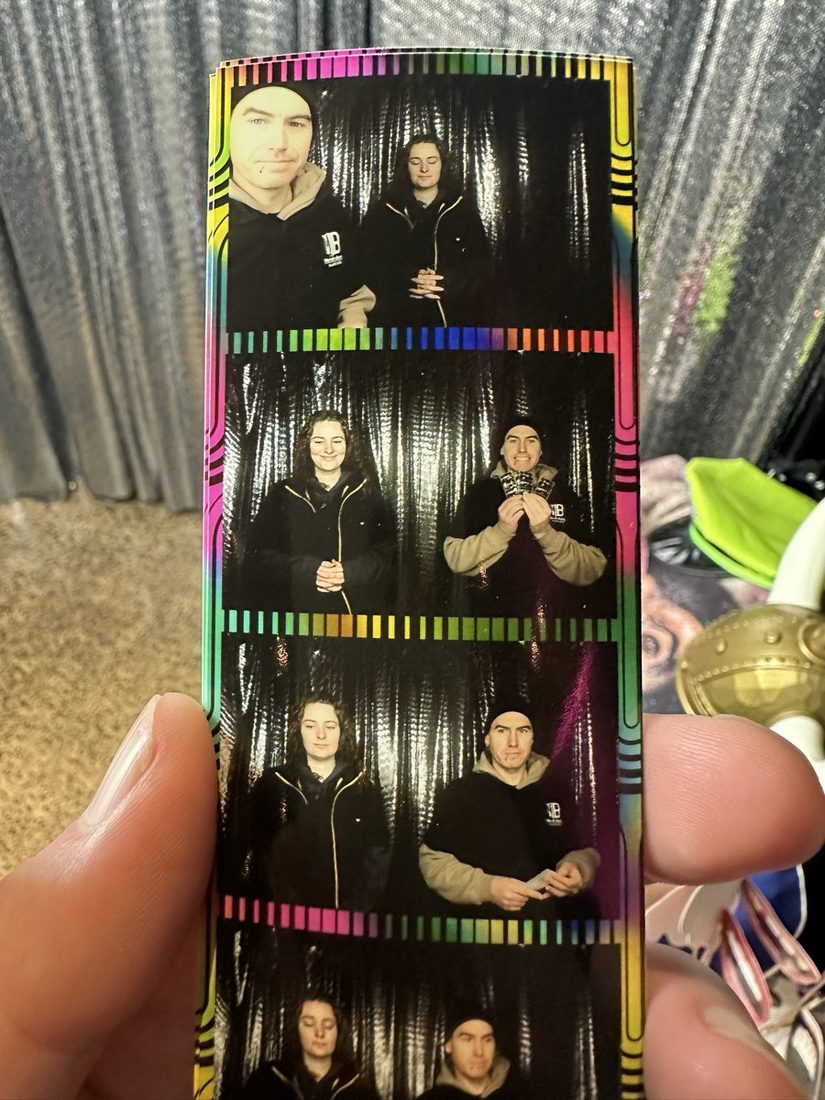 A photo strip fresh out of the booth, held in one hand
